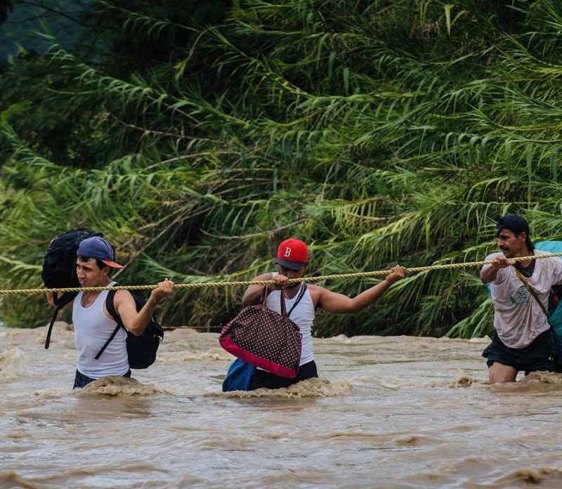 Migrantes cruzando un río